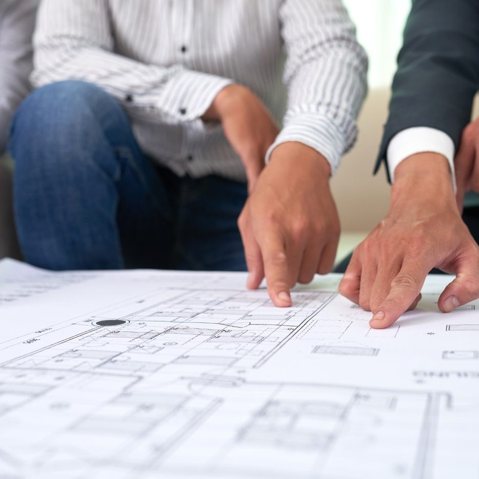 Manos revisando los planos de un proyecto